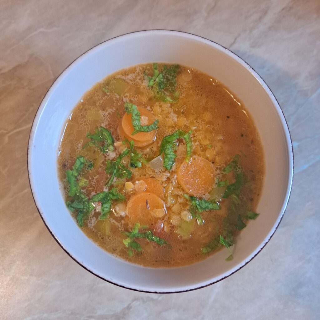 Simple Red Lentil Soup served in a small bowl, topped with finely chopped fresh parsley.
