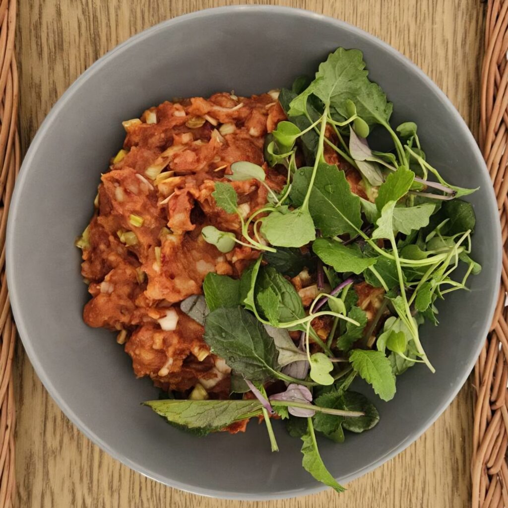 Dried Pepper Potato Mash served in a deep bowl, decorated with a mix of fresh microgreens on top.